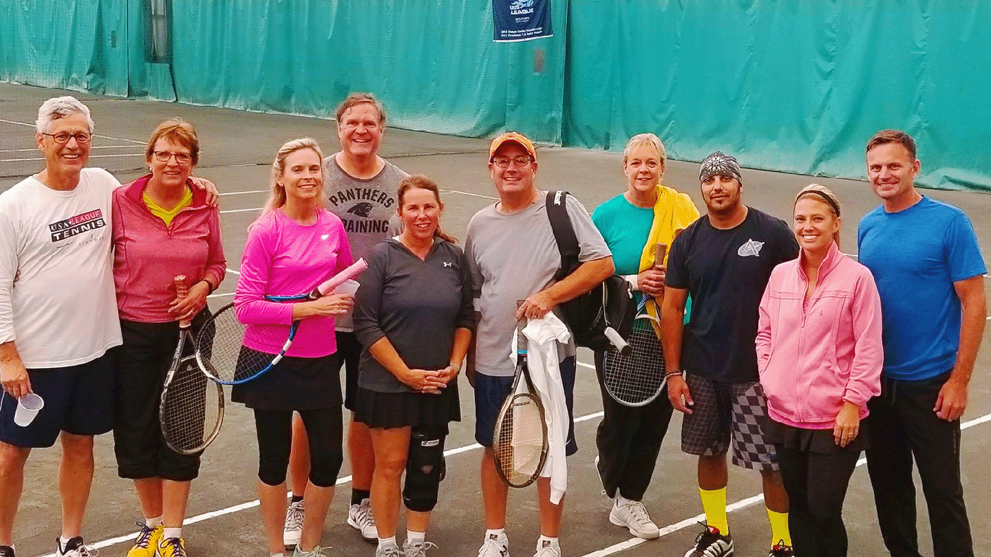 Members standing on the indoor tennis courts